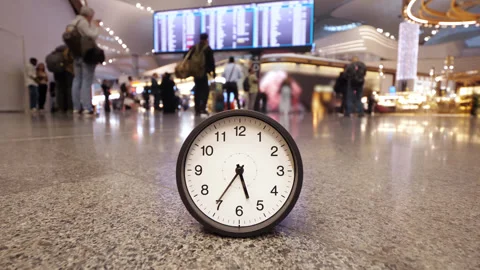Time crunch concept showing racing clock on busy airport departures floor Stock Footage 345553445