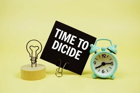Time To Dicide text message on paper card with alarm clcok on yellow backgrou Foto stock