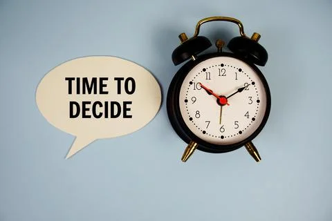 Time to dicide text on speech bluble with alarm clock top view on blue back.. Stock Photos
