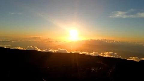 Time Elapse of setting sun above moving clouds at top of Haleakala Crater Summit Stock Footage 119654139