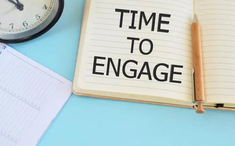 Time to engage text written in Notebook. Lightblue background. Business conce Stock Photos