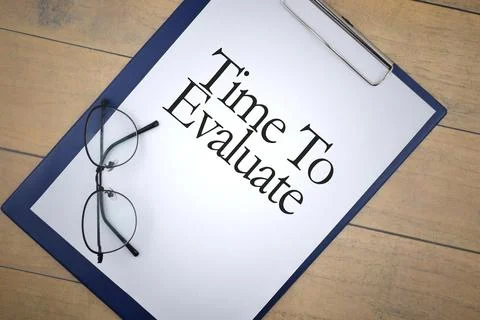 Time To Evaluate wording on file with spectacles on wooden background. Busine Stock Photos