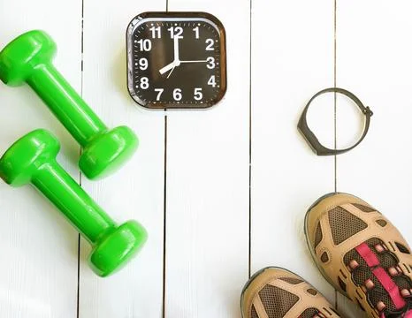 Time for exercising concept. alarm clock and dumbbells Stock Photos