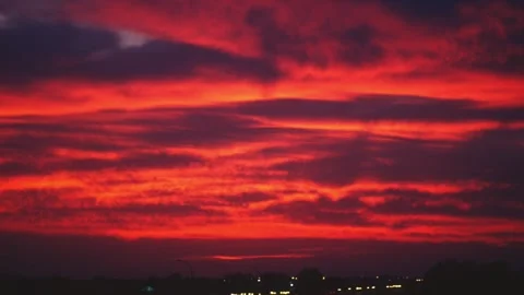 Time exposure plane takeoff, after bright red cloud shapes Stock Footage 302649338
