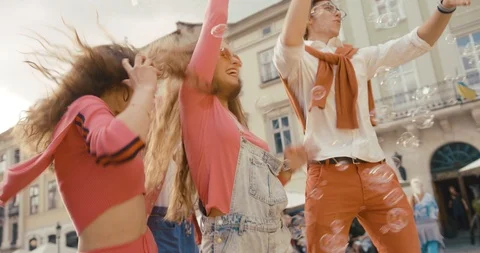 Time with friends. Two couples of happy young people dance on the square among Stock Footage 95123636