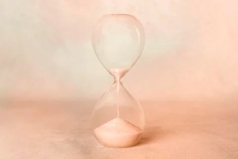 Time. An hourglass with sand falling through. Old age, nostalgia concept, sepia Stock Photos