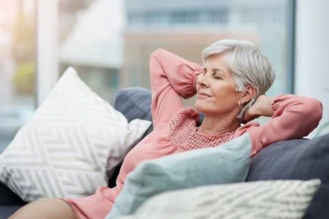Time to kick back and relax. cheerful mature woman laid back and relaxing on her Stock Photos