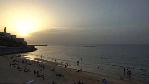 Time laps of beautiful sunset at beach in Tel Aviv Jaffa with poeple swimming an Stock Footage