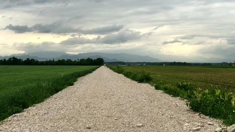 Time laps evening clouds moving over the dirt road leading to horizon 스톡 동영상 130592358