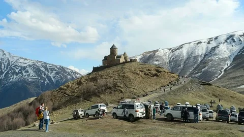 Time-laps parking and tourists on mountains near Trinity Church, Gergeti. Stock Footage 75532859