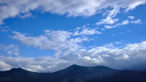 Time lapse 4K footage of cloudy blue sky over mountain ridge Stock Footage 92239178