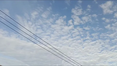 Time lapse of Altocumulus clouds a bove three stretched cables Stock Footage 325977712