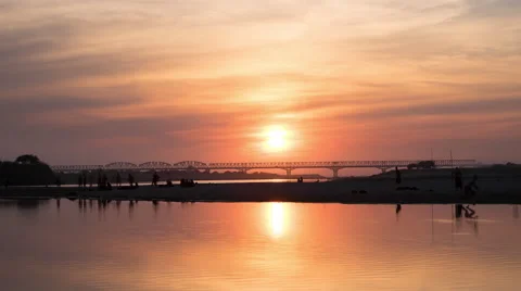 Time lapse of amazing sunset and local people on irrawaddy river near bridge Stock Footage 45898100