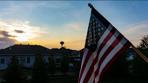 Time-lapse of American Flag during a sunset in a midwestern town. Stock Footage