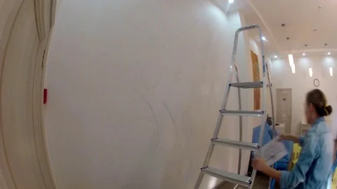 A time lapse of the artist which makes a painting of the tree on the wall (with Video stock 77004198