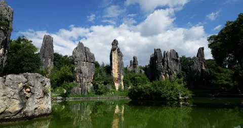 Time-lapse of Ashima Rock across small pond, fast clouds on sky Stock-Footage 329595692