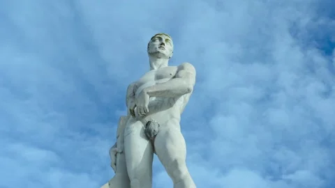 Time lapse of athlete statue, hero with moving clouds Stock Footage