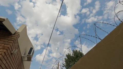 Time lapse of barbed wire and a air conditioning unit with clouds Stock Footage 155012384