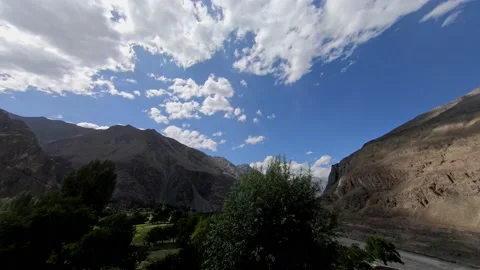 Time lapse of barren mountain in valley with clouds against the blue sky Stock Footage 170693646