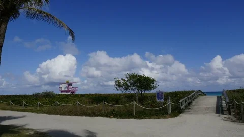 Time lapse of beach, clouds, dirt road scene with lifeguard house in background Stock Footage 72801606