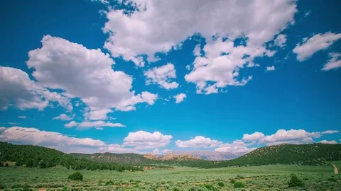 Time Lapse - Beautiful Clouds Moving Over Green Fields - 4K Stock Footage 77566365