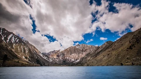 Time Lapse - Beautiful Clouds Moving Over the Mountain Range by the Lake  - 4K Stock Footage 97837600