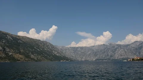 Time lapse of beautiful clouds over the hill in a water bay 動画素材 115827999