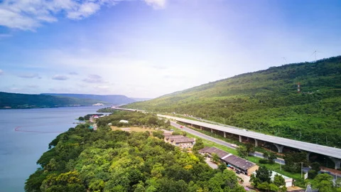 Time lapse of beautiful expressway in a green forest with a dam on the side. Stock Footage 166018934