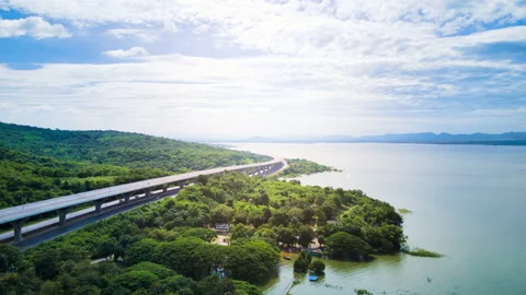 Time lapse of beautiful expressway in a green forest with a dam on the side. Stock Footage 166018940