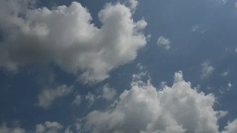 Time lapse of beautiful puffy summer clouds moving through a pale blue sky Stock Footage 312481029