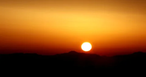 Time lapse of beautiful sun rising over mountain and hiding behind dark clouds Stock Footage 72289081