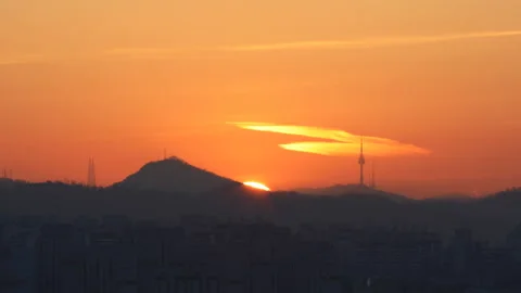 Time lapse of beautiful sun rising behind Namsan and Seoul tower in Korea Stock Footage 162711243