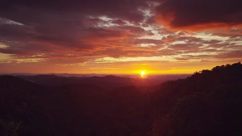Time-lapse of beautiful sunrise clouds over the silhouetted layers of mountains Stock Footage 103402017