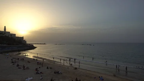 Time lapse of beautiful sunset at beach in Tel Aviv Jaffa with people swimming a Stock Footage 97632369