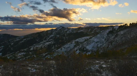 Time lapse-Beautiful sunset lit clouds roll over dark mountain Stock Footage 68333202