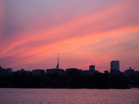 Time lapse of beautiful sunset reflected on lake over skyscraper Stock Footage 76729207