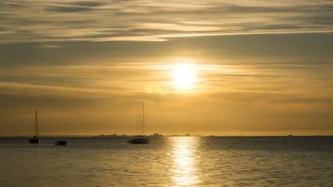 Time lapse of beautiful yellow sunset with the ocean and sailing boats Stock Footage 133412140