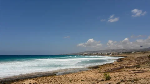 Time lapse of big breaking ocean waves on a sandy beach with waving Greek flag Stock Footage 222994152