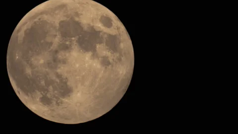 Time Lapse Of Big Full Moon Rising Or Moving Through Warm Air In The Night Sky Stock Footage