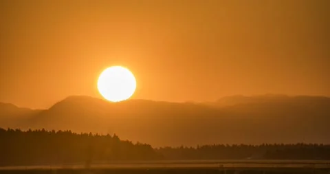 Time lapse of big sun setting behind the mountains Stock Footage 158990384