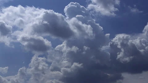 Time-lapse of Billowing cumulus clouds moving across a vibrant blue sky Stock Footage 340472728