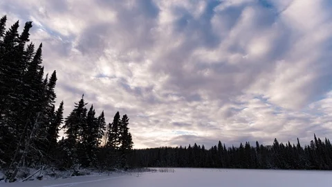 Time lapse of blowing clouds over a frozen snow covered lake Stock Footage 120934909