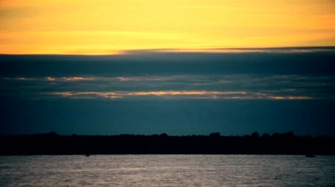 Time lapse of blue and orange colorful clouds at dawn over a river Video stock 67602358
