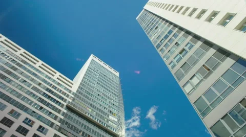 Time-lapse blue cloudy sky white glass buildings  Stock Footage 67747948