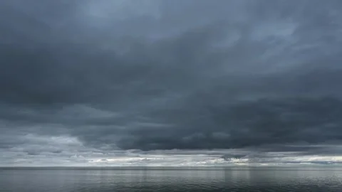 Time lapse of a blue-gray stormy clouds moving across the sky above a large Stock Footage 335550005