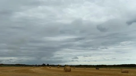 Time lapse of blue-grey colored clouds moving above a harvested field Stock Footage 139822585