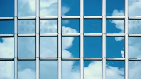 Time lapse of blue sky and clouds reflected in structural modular glass wall. Video stock 138990294