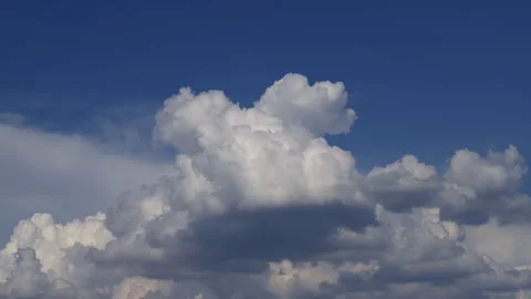 Time-lapse of blue sky and flowing white clouds under warm sunlight Stock Footage 308929098