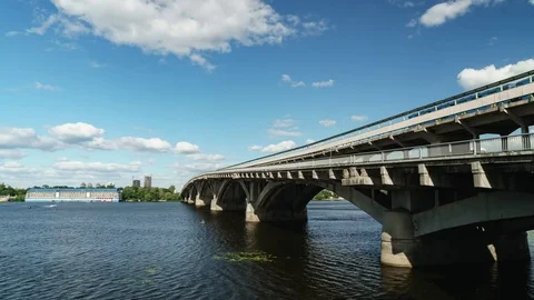 Time lapse blue sky, clouds and river. Cars traffic on the bridge of city Stock Footage 77585131