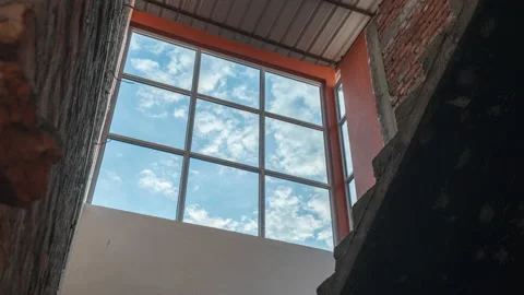 Time lapse of blue sky clouds through window city building Stock Footage 168898950